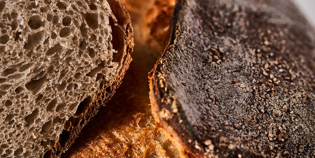 Campasine bread cut in half, with the crumb and topping clearly visible.