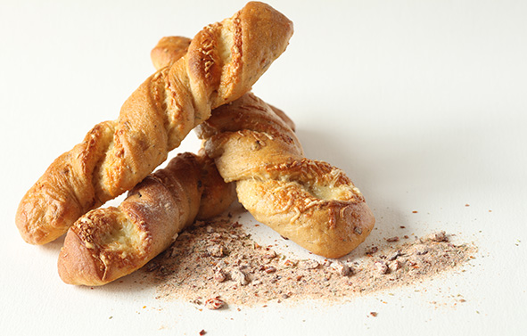 Three twisted breads placed on a light surface, with Phil Tex-Mex powder sprinkled on the surface nearby
