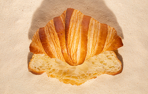 Croissant cortado por la mitad a lo largo, colocado sobre masa madre en polvo.